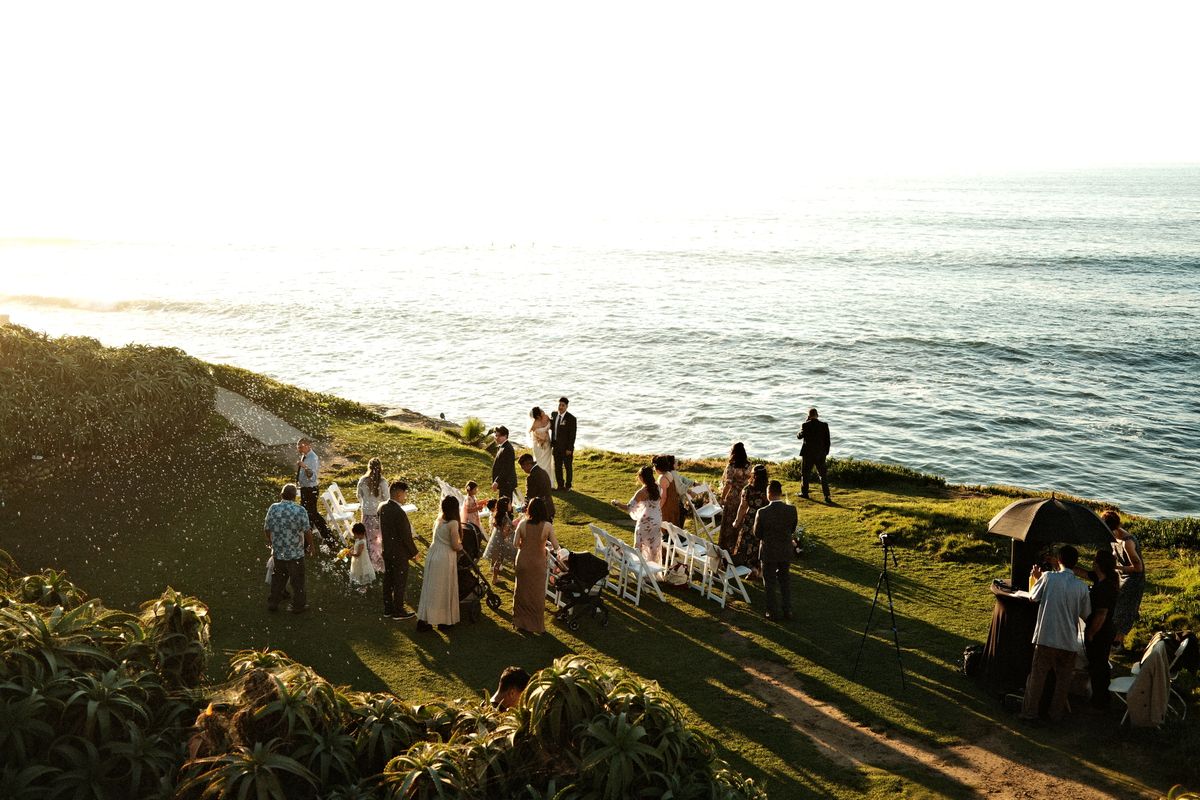 Ceremonia de boda al aire libre junto al mar, bajo la luz del atardecer